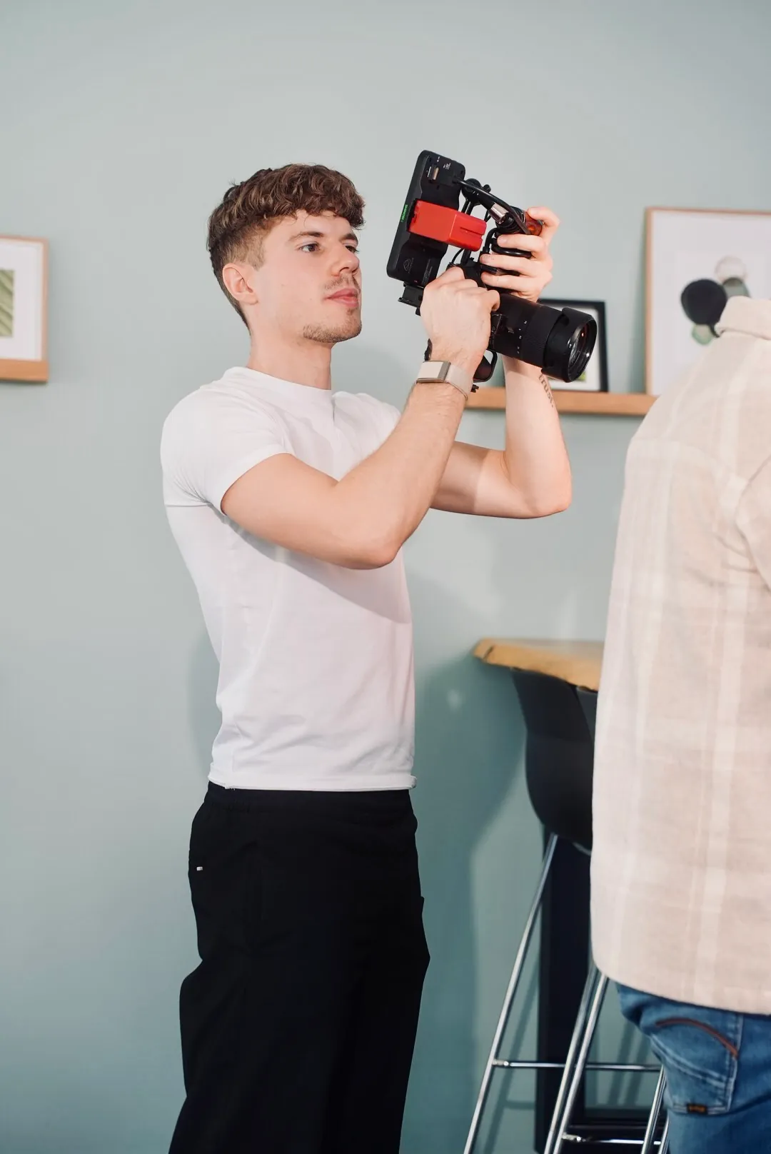 Videograf filmt mit einer Handkamera mit rotem Rig