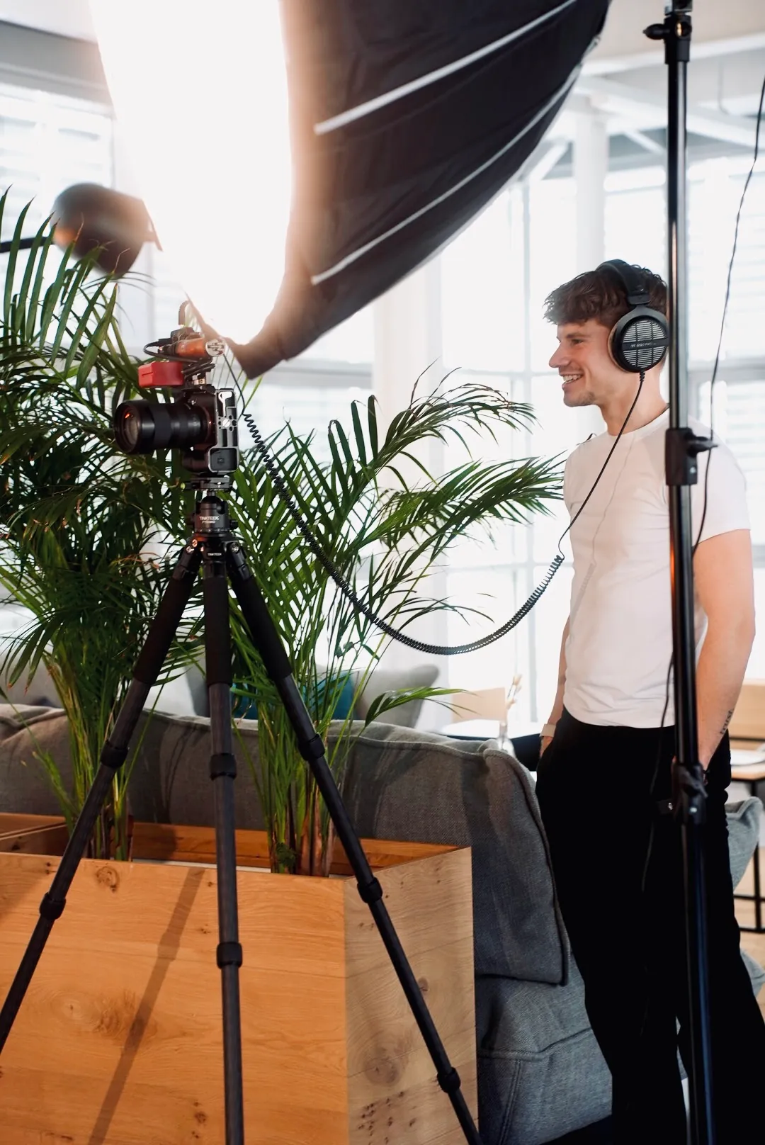 Interview-Set mit Kamera auf Stativ, Softbox und Teammitglied mit Kopfhörern