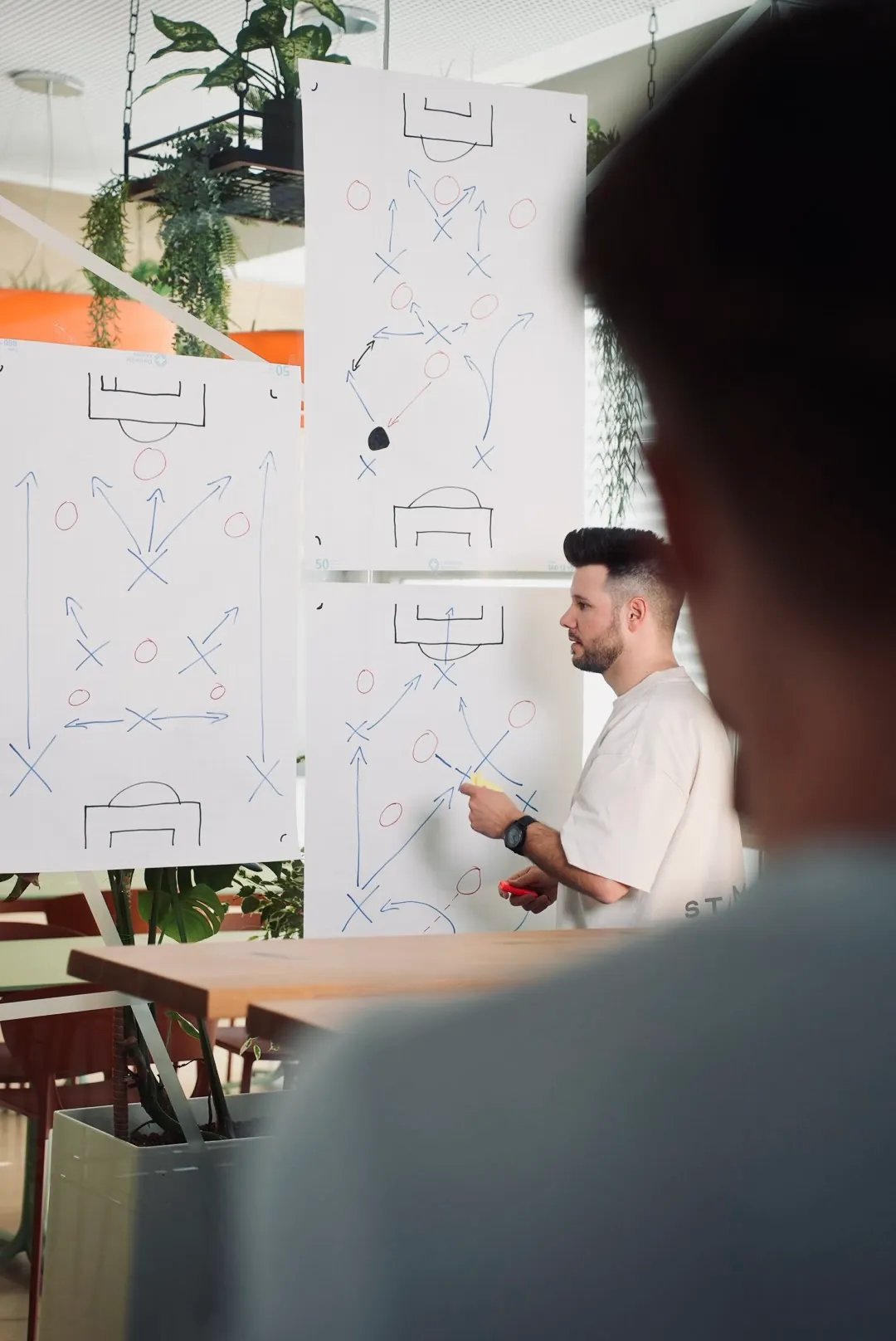 Dreh vor einem Whiteboard, im Vordergrund unscharf der Kameramann